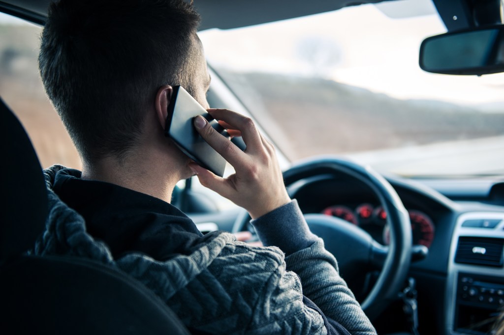 Man talking on a mobile phone while driving car.