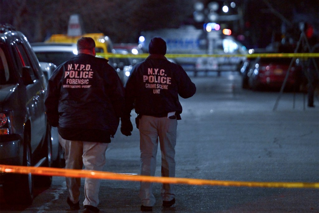 Two NYPD officers walk to a crime scene. 