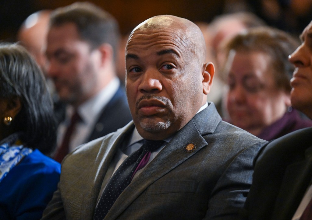 Carl Heastie sitting in a crowd with a serious look