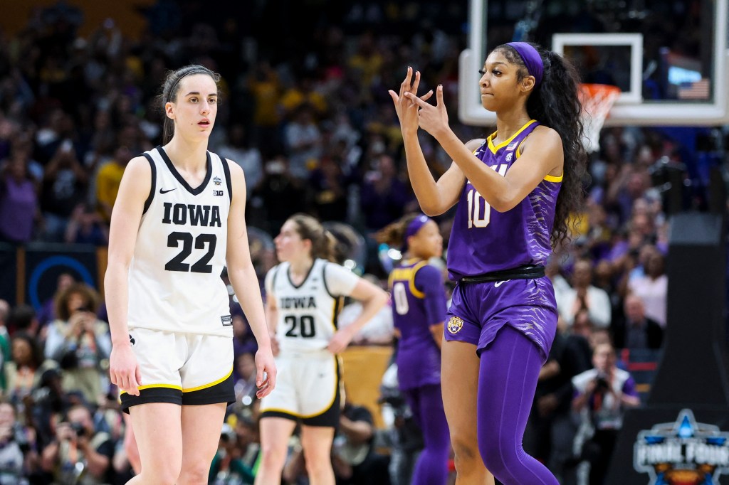 Angel Reese (right) gestures to her ring finger at the end of LSU's NCAA championship win over Iowa April 2, 2023. 