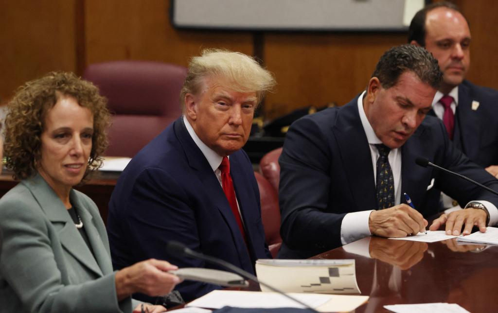 Former U.S. President Donald Trump is accompanied by members of his legal team, Susan Necheles and Joe Tacopina, as he appears in court for an arraignment on charges