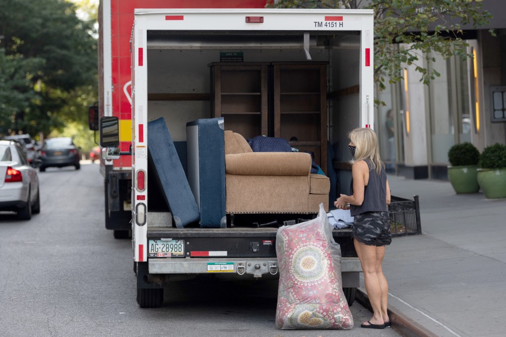 Woman loads moving truck in NYC.