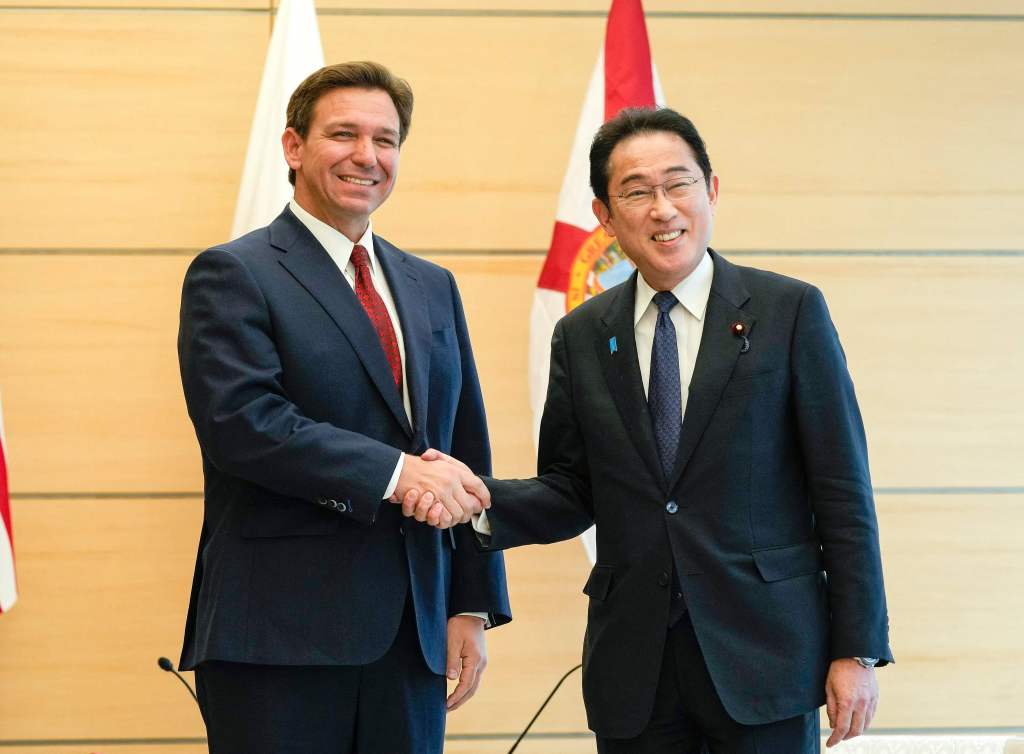 Florida Governor Ron DeSantis (L) shakes hands with Japanese Prime Minister Fumio Kishida