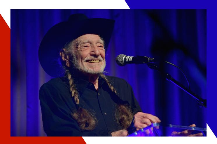 Willie Nelson smiles while performing.
