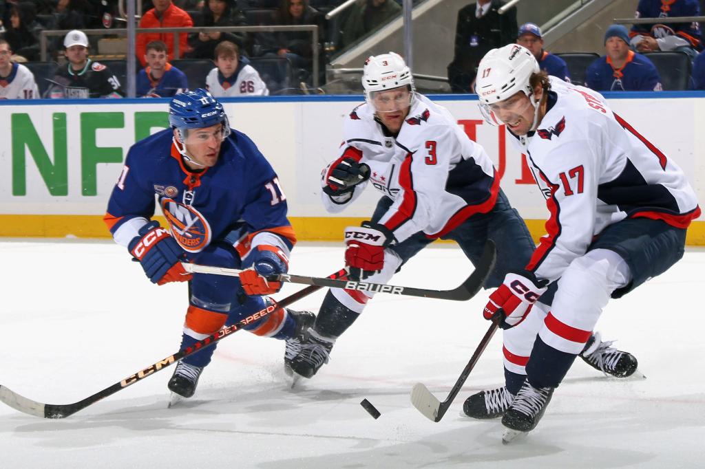 Nick Jensen #3 and Dylan Strome #17 of the Washington Capitals defend against Zach Parise #11 of the New York Islanders during the second period at the UBS Arena on March 11, 2023 in Elmont, New York.