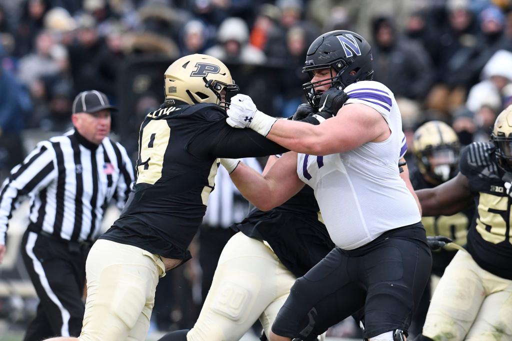 Northwestern Wildcats offensive lineman Peter Skoronski (77) blocks Purdue Boilermakers defensive end Jack Sullivan (99) during the college football game between the Northwestern Wildcats and the Purdue Boilermakers on November 19, 2022, at Ross-Ade Stadium in West Lafayette, Indiana.