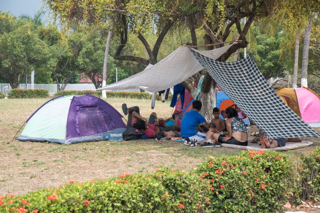 Migrants rest in a tent set up in Tapachula, waiting for their 40 day traveling pass to cross Mexico to reach the US.