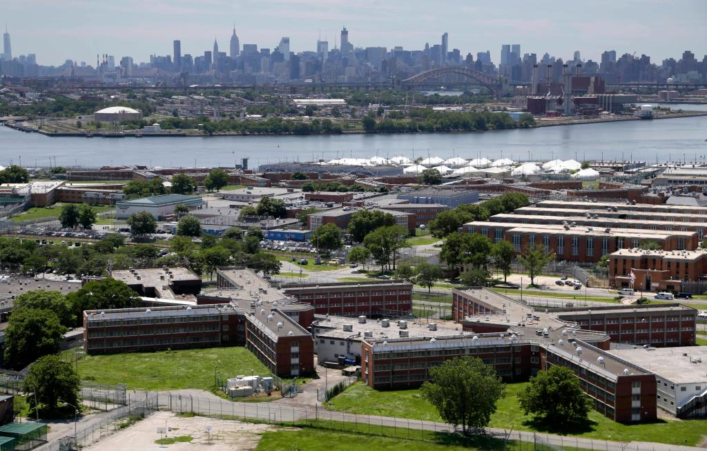 In a June 20, 2014, file photo, the Rikers Island jail complex stands in New York with the Manhattan skyline in the background