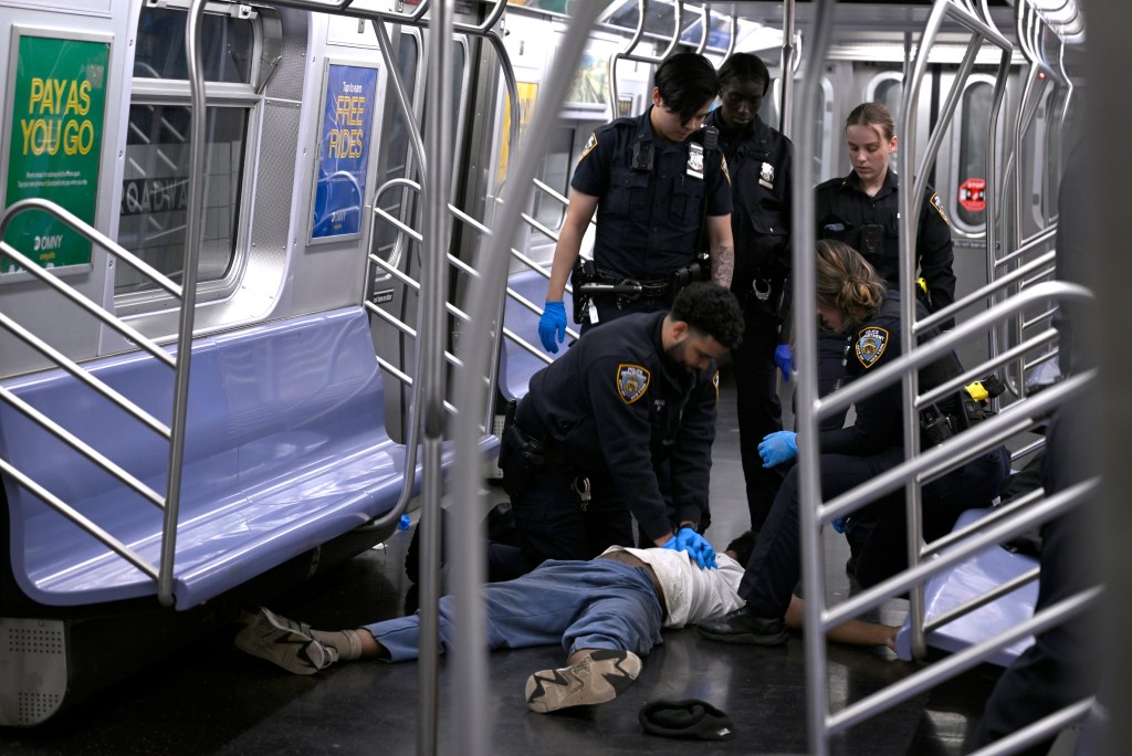 First responders giving the man medical attention on the F train.