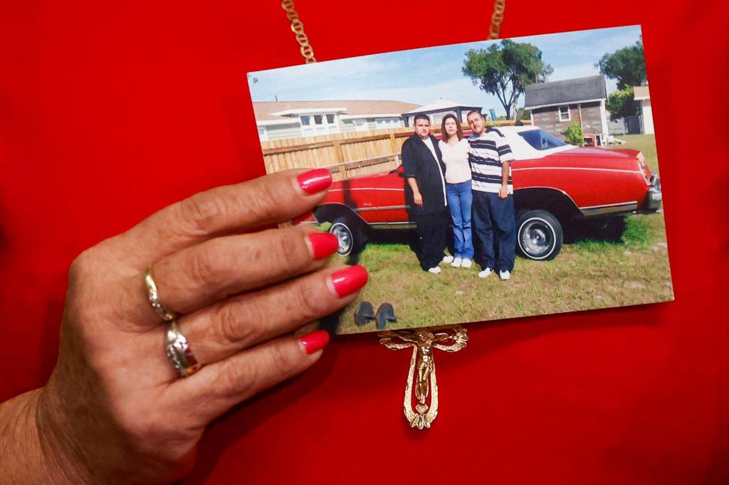 Paz Quezada, left, who is the mother of Juan and Sergio Guitron, holds a photo of her with her children