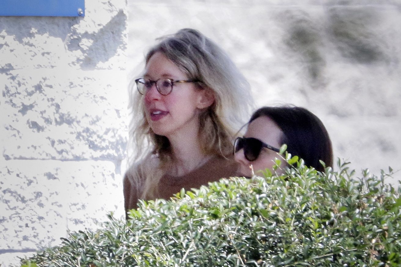 Elizabeth Holmes is escorted by prison officials into the federal women's prison camp.