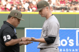 Clarke Schmidt's hand is checked by umpires during the Yankees-Reds game on May 19.