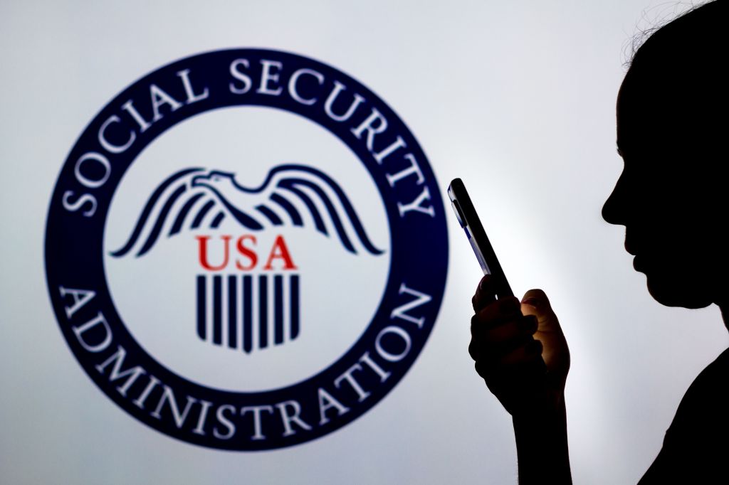 Woman's silhouette holds a smartphone with the United States Social Security Administration logo in the background