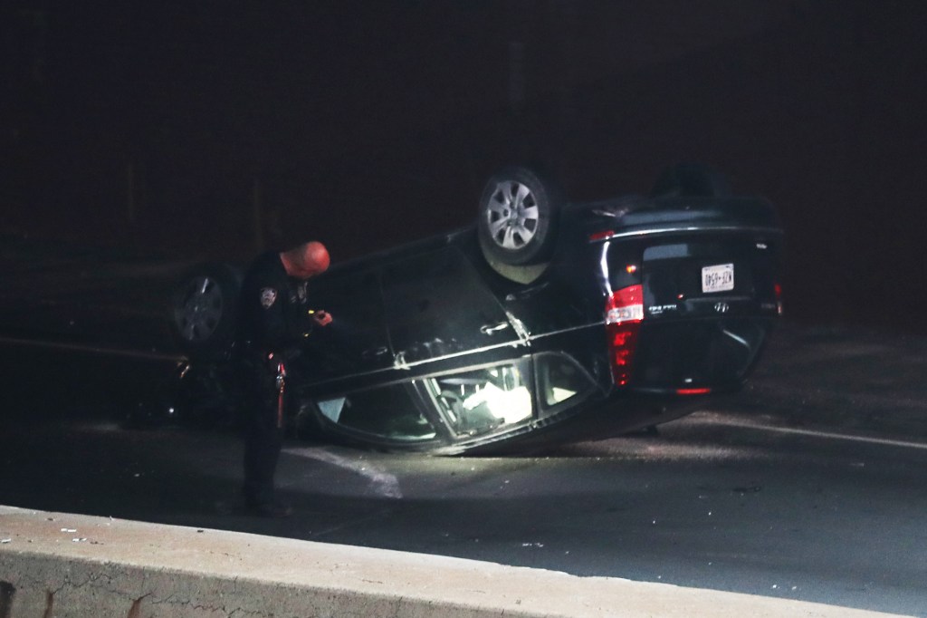 The flipped-over Hyundai Sonata seen on the side of the Bruckner Expressway.