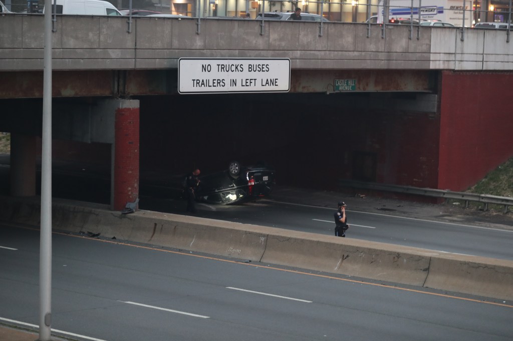 The flipped-over Hyundai Sonata seen on the side of the Bruckner Expressway.