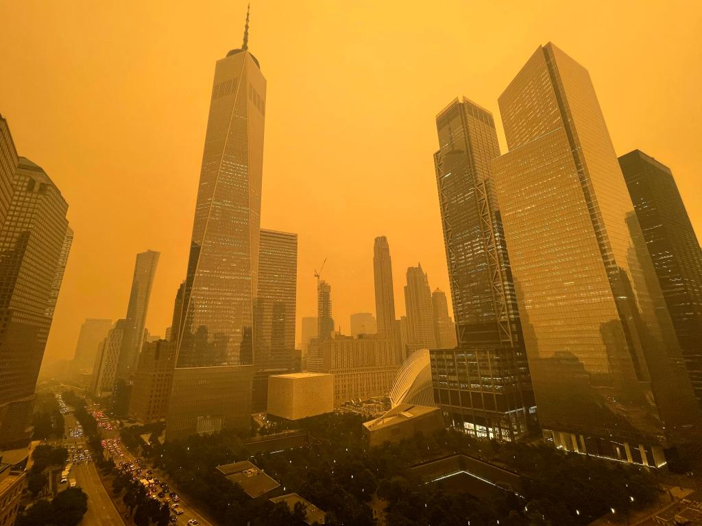 The sky glows amber around the One World Trade Center.