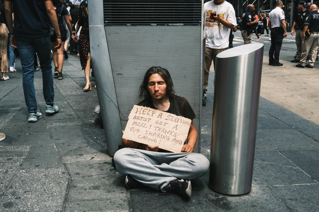 A homeless man asks for money in Times Square.