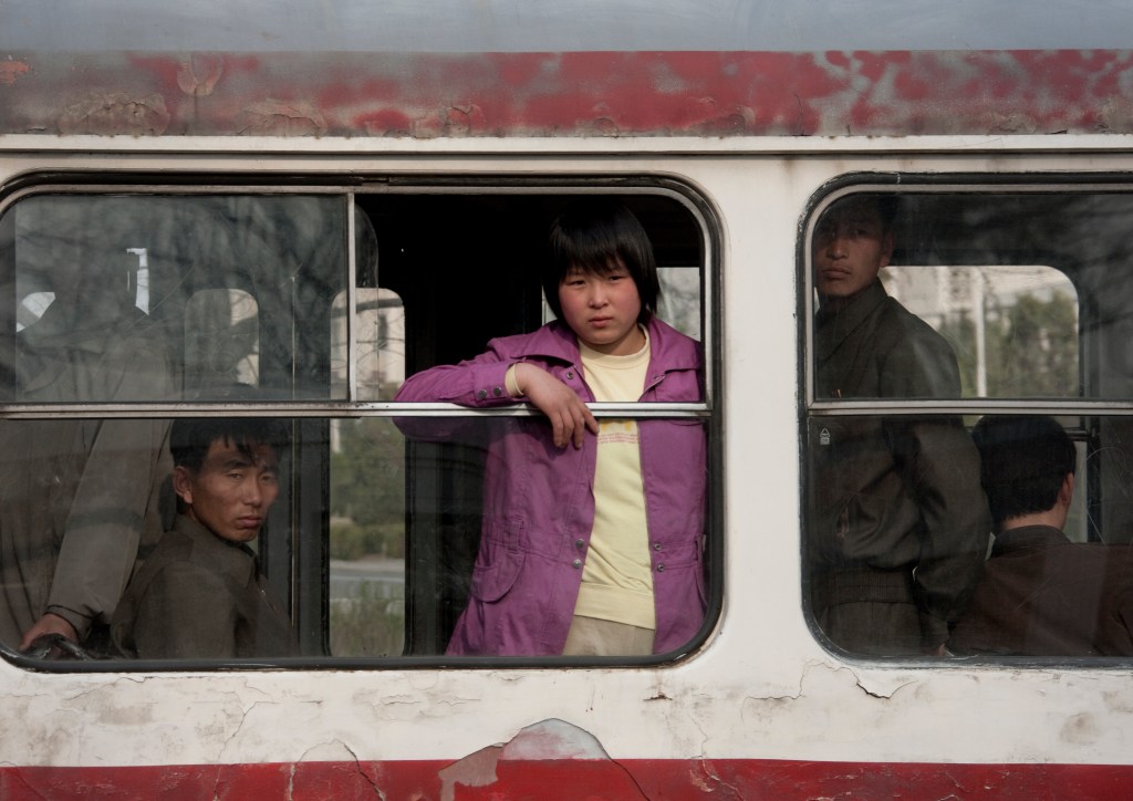 North Korean people at the window of in an old bus, Pyongan Province, Pyongyang, North Korea 