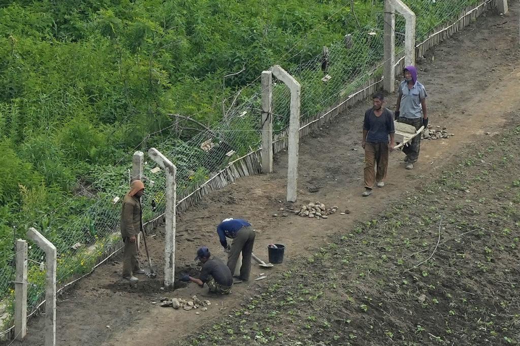 People constructing fences along North Korean border. 