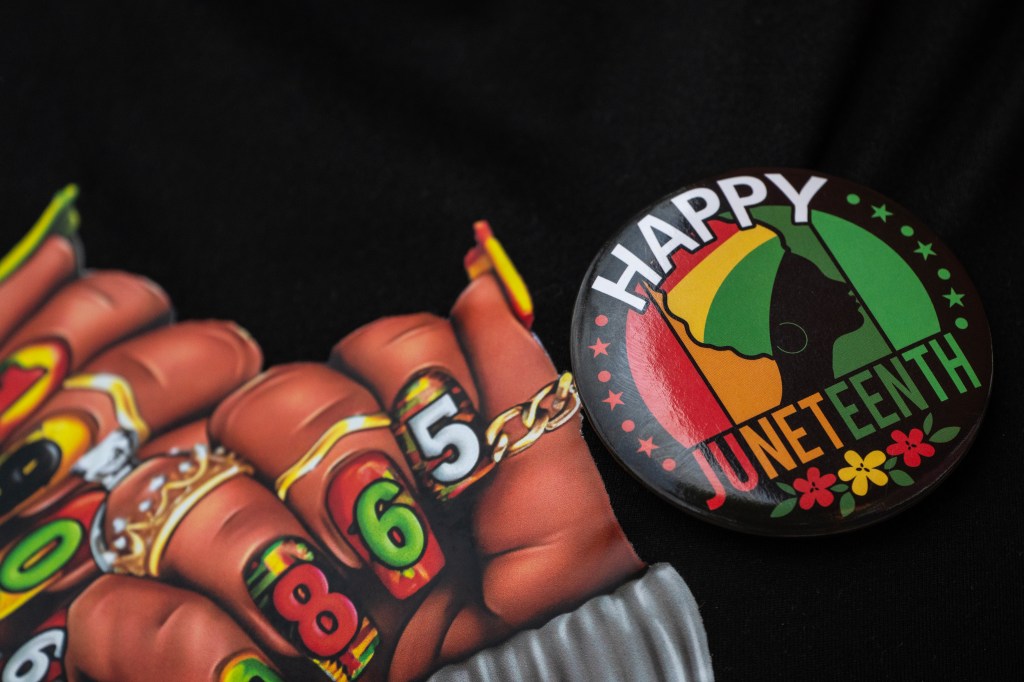 A vendor displays Juneteenth-themed clothing during a neighborhood Juneteenth festival in Washington, DC.