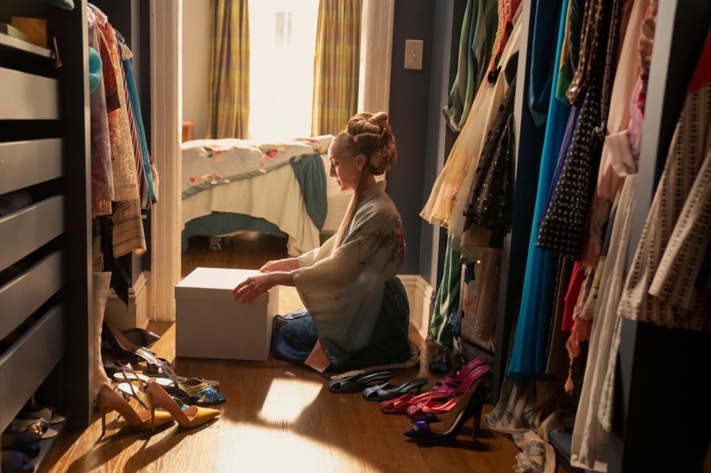 Carrie (Sarah Jessica Parker) in her closet, kneeling. 