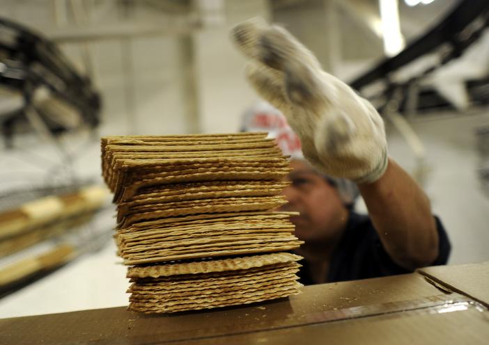 A worker at Streitâs Matzo factory on the Lower East Side of New York stacks matzo wafers on May 9, 2012.