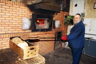 Rabbi Jacob Richter takes the Matzoh out from the oven at the Satmar Matzoh bakery in Williamsburg, Brooklyn.