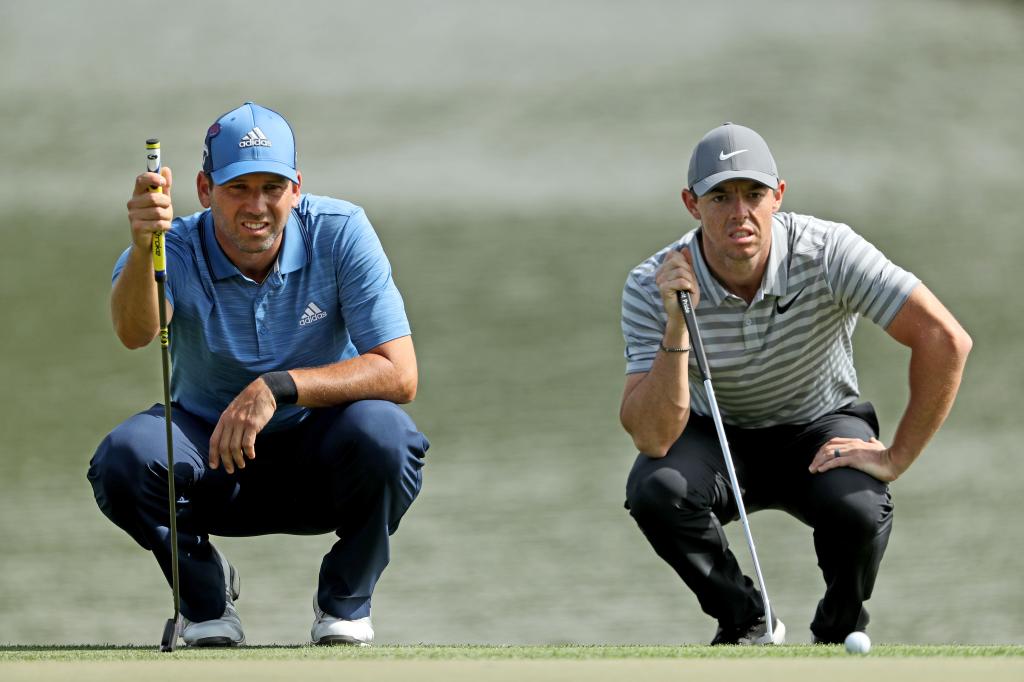 Rory McIlroy and Sergio Garcia line up their putts on the par 4, ninth hole during the first round of the Omega Dubai Desert Classic