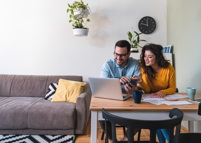 Couple smiles after successfully raising their credit scores utilizing debt consolidation