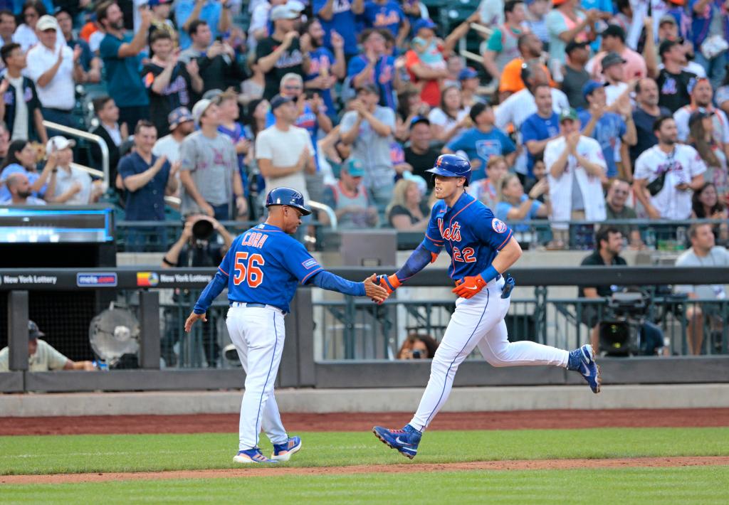 New York Mets third baseman Brett Baty #22 is greeted by New York Mets infield & third base coach Joey Cora #56 rounding the bases on his solo homer during the first inning.