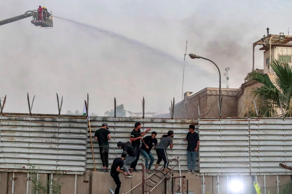 The videos showed dozens of men climbing over the fence at the complex, with the sound of them trying to break down a front door.