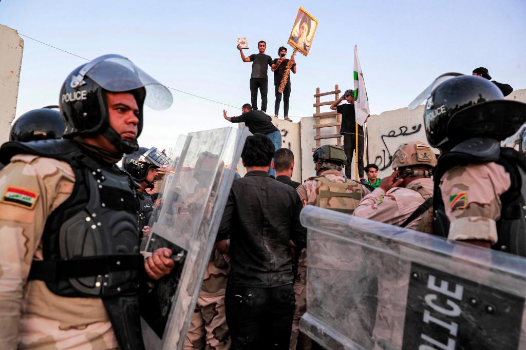 Iraqi riot police try to disperse supporters of Iraqi Shiite cleric Moqtada al-Sadr gathering for a protest outside the Swedish embassy in Baghdad on July 20, 2023. 