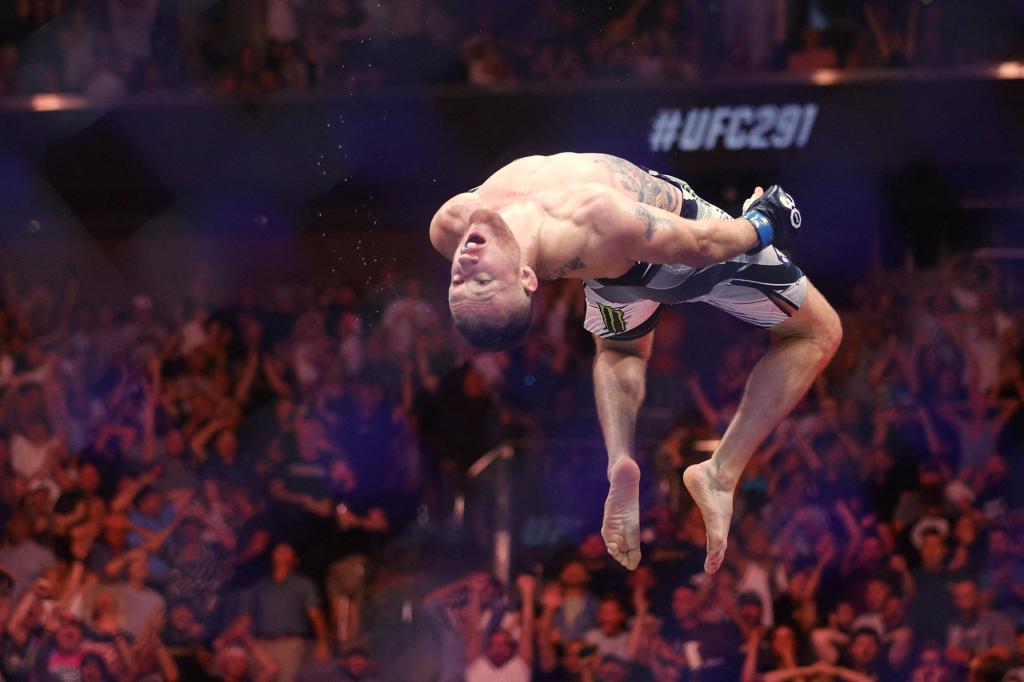 Justin Gaethje soars for his signature backflip celebration off the top of the cage.