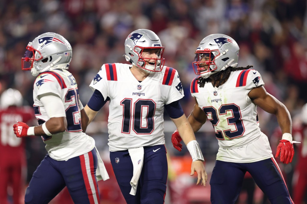 Mac Jones #10 of the New England Patriots celebrates with Marcus Jones #25 and Kyle Dugger #23.