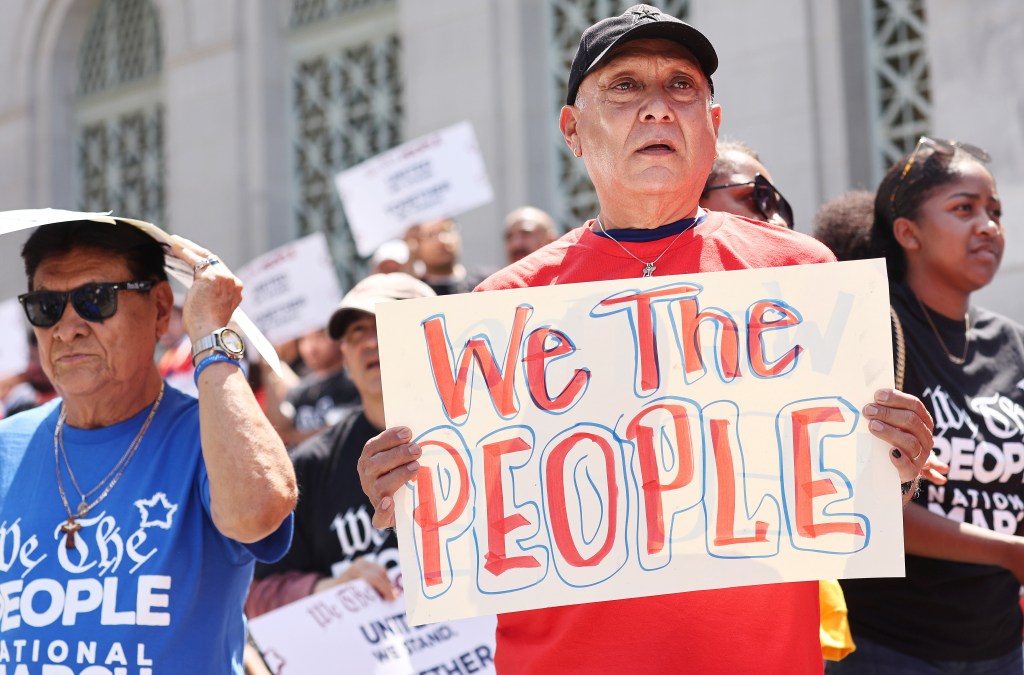 Demonstrators hold signs during the We The People March in protest of the hundreds of bills being introduced which are directed towards LGTBQ+ people, people of color and women on July 2, 2023 in Los Angeles, California. 