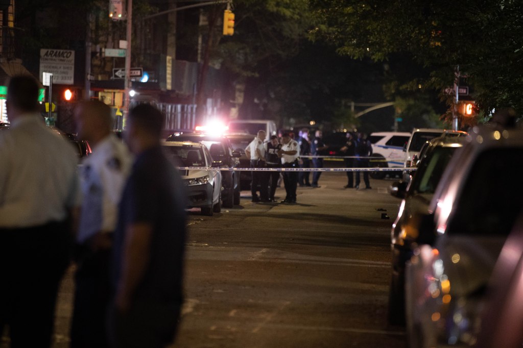 Police officers are seen at the scene of a shooting on Morris Ave. 