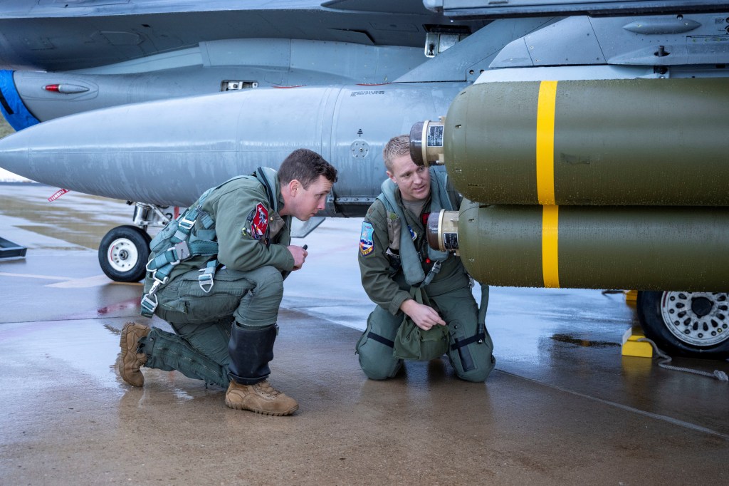 US troops inspect a cluster bomb