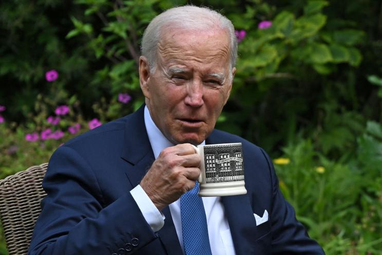 Biden drinking tea from a Downing Street mug.