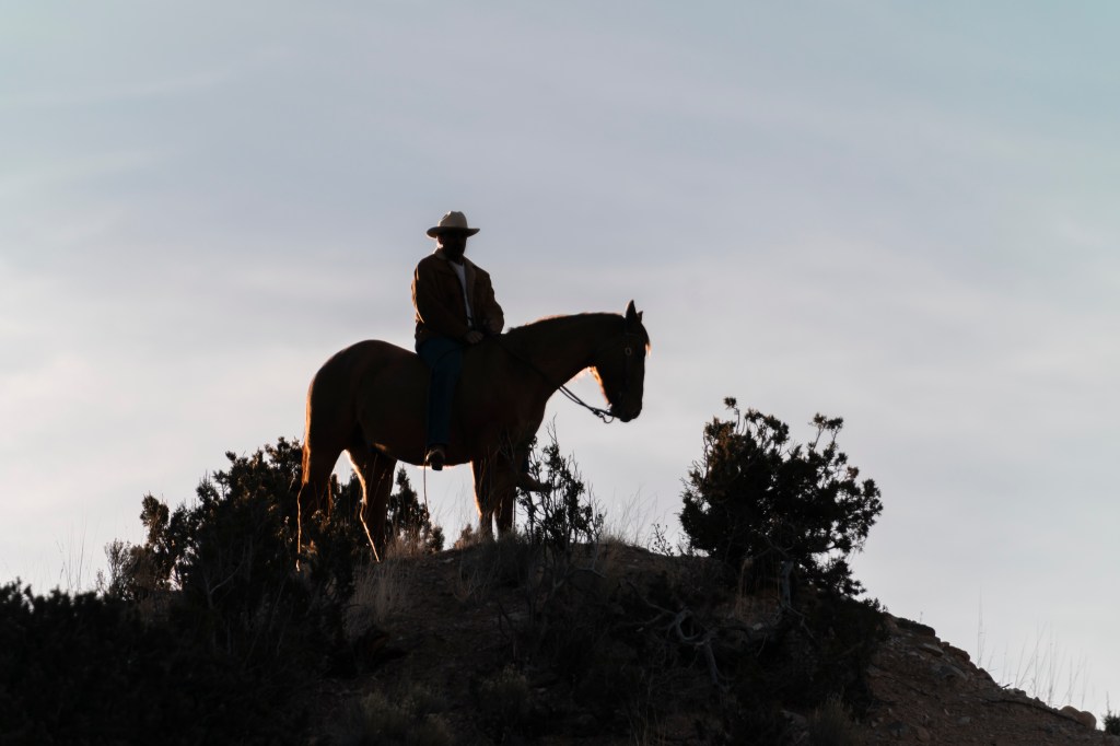 Zahn McClarnon sitting on a horse. 