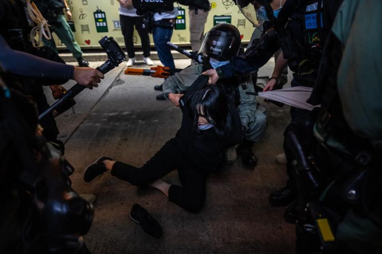 Riot police officers arrest a pro-democracy protester during a march in the Central district of Hong Kong on June 9, 2020 in Hong Kong