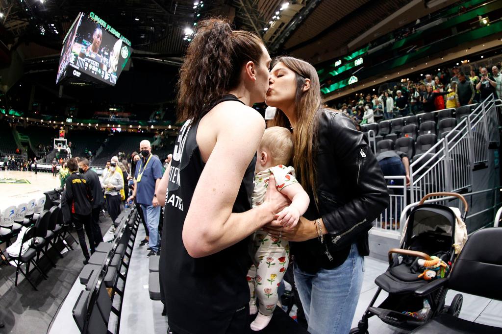 Breanna Stewart kisses wife Marta Xargay and holds daughter Ruby.