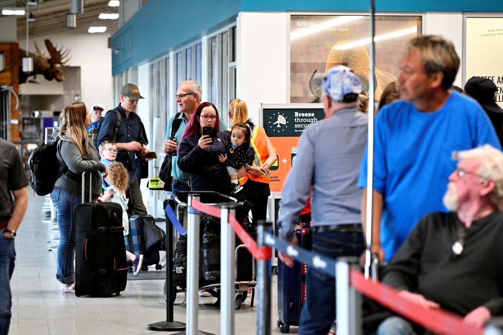 People wait in line at the airport, as they prepare to be evacuated from wildfires threatening the Northwest Territories town of Yellowknife, Canada, on Aug. 17, 2023.  