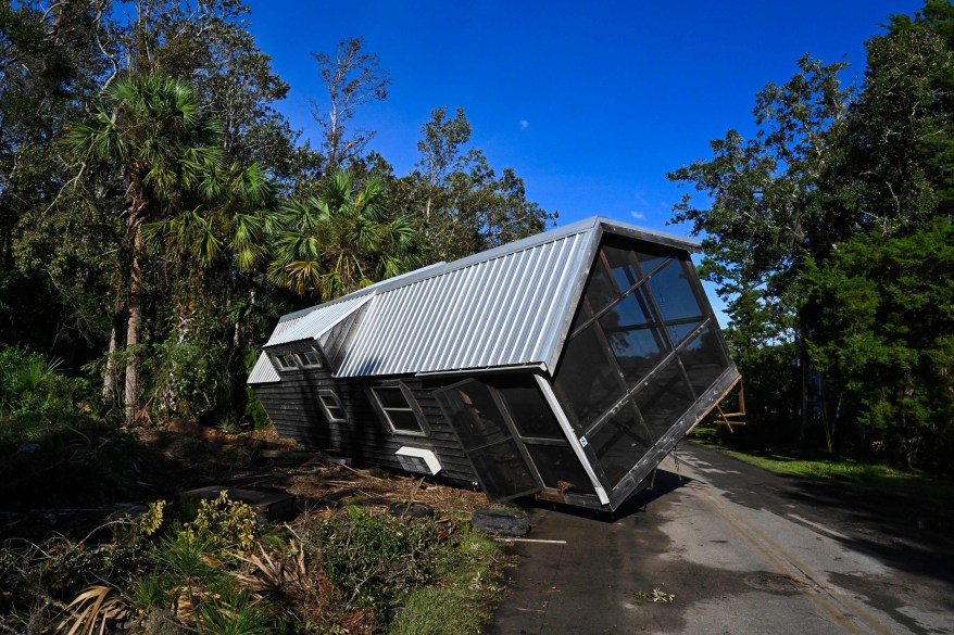 A displaced damaged mobilhome is seen in the middle of a road.