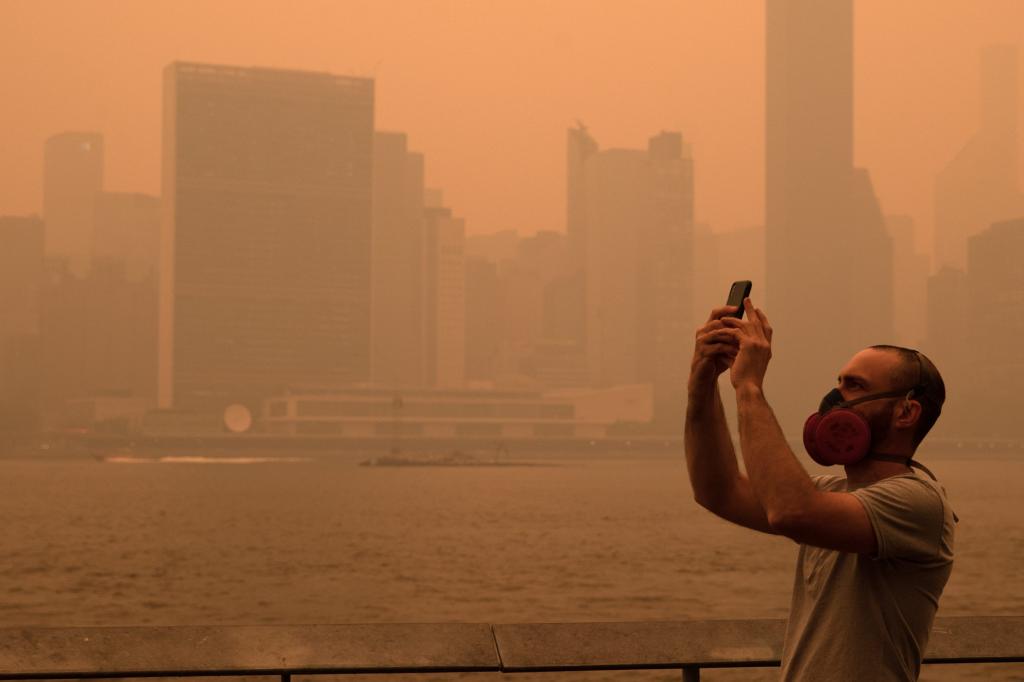 A man taking a picture of the sky while wearing a mask on June 7. 