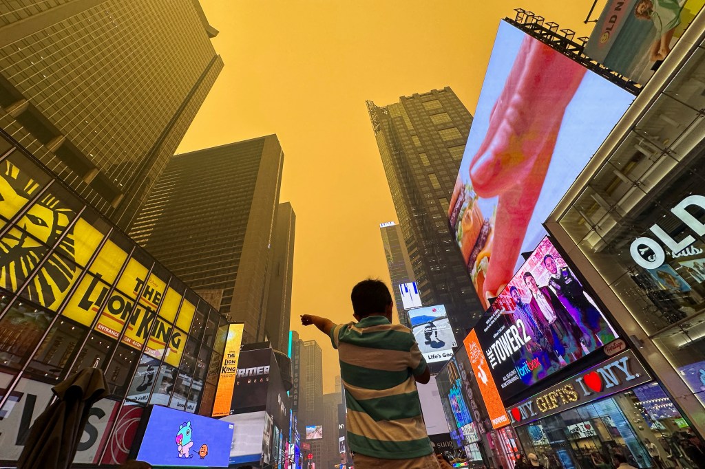 A boy pointed toward the orange sky on June 7. 