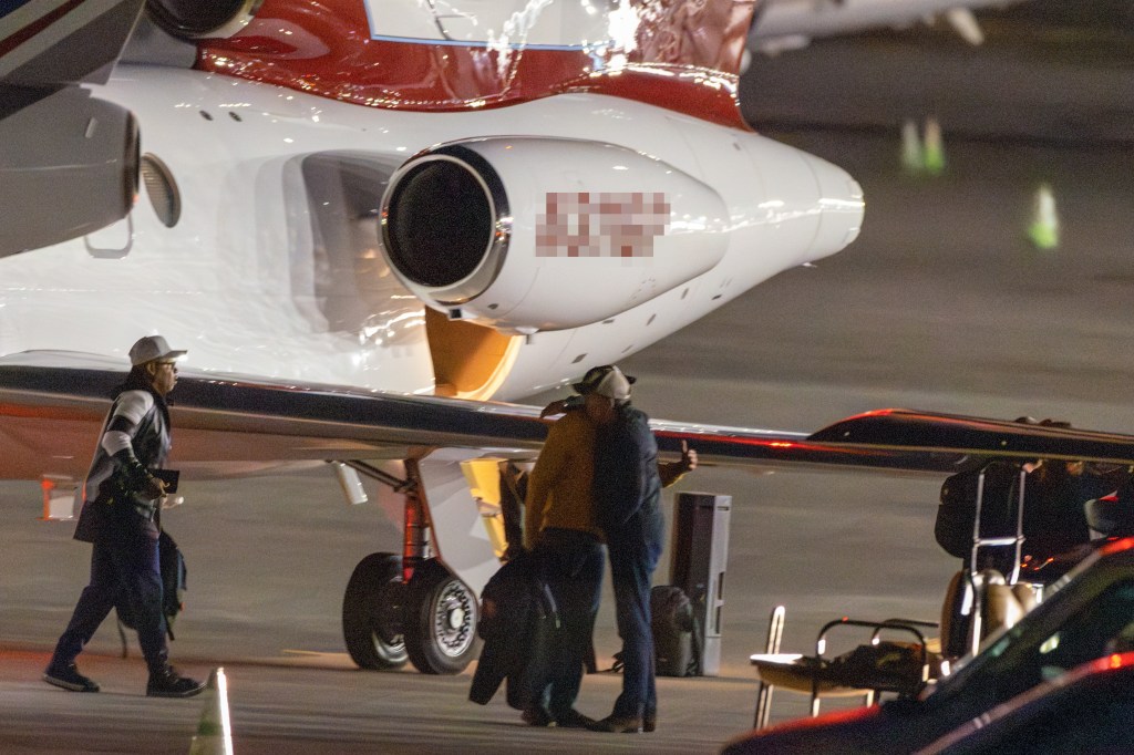 Hunter Biden hugging an unknown person in front of a private jet.