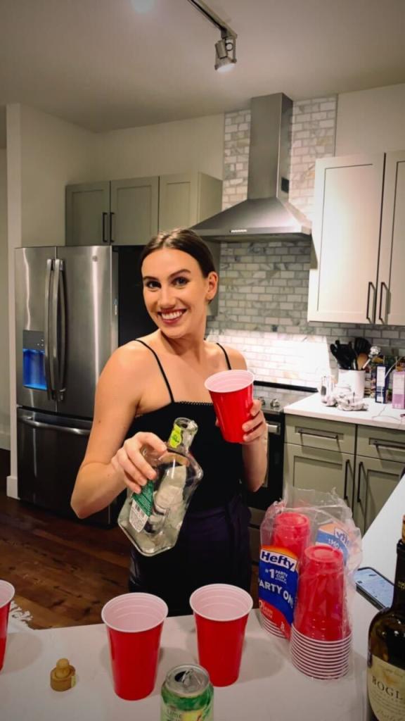 Grace Adams, 25, living on the Upper East Side, pouring drinks in her Gramercy Park apartment in 2022.