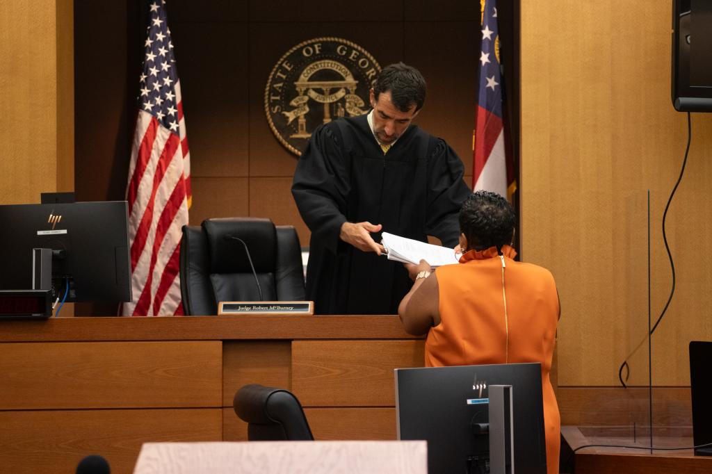 Fulton County Superior Court Judge Robert McBurney receives documents from County Court Clerk Che Alexander on August 14, 2023 in Atlanta, Georgia