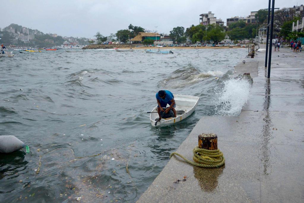 man in a boat is pictured in the flooded Mexican town of Santa Rosalia