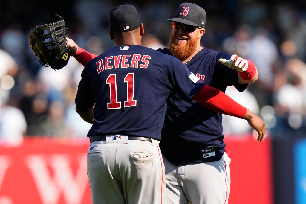 Boston Red Sox's Justin Turner, right, hugs Rafael Devers